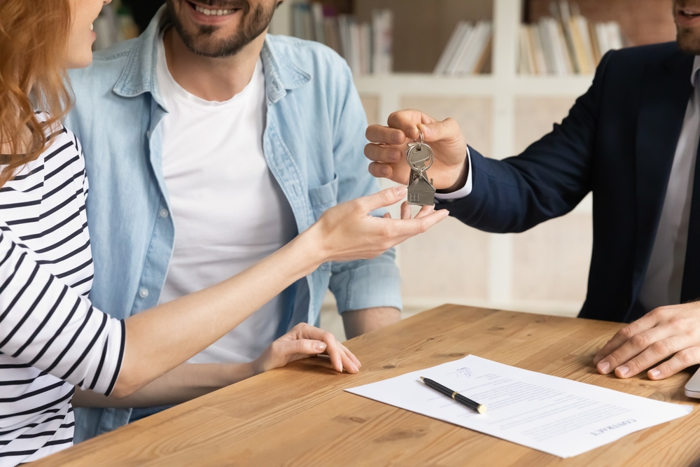 an agent handing the home key to the couple