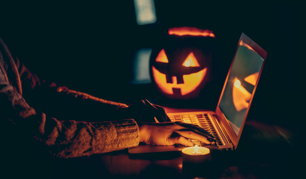 a man using a laptop with his scary pumpkin light