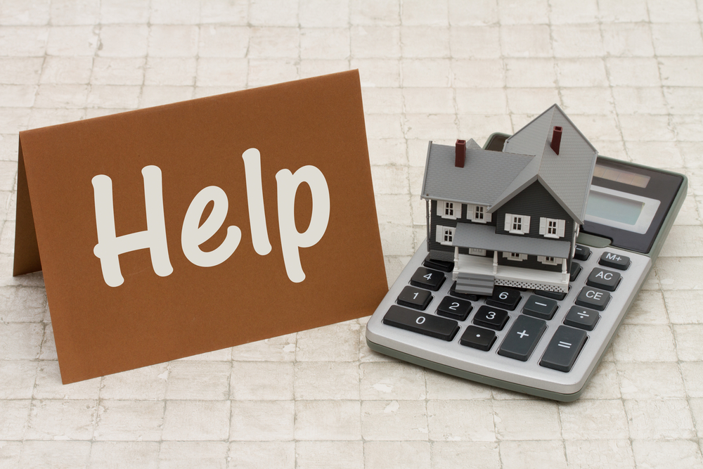 a miniature house on top of the calculator with the signage help