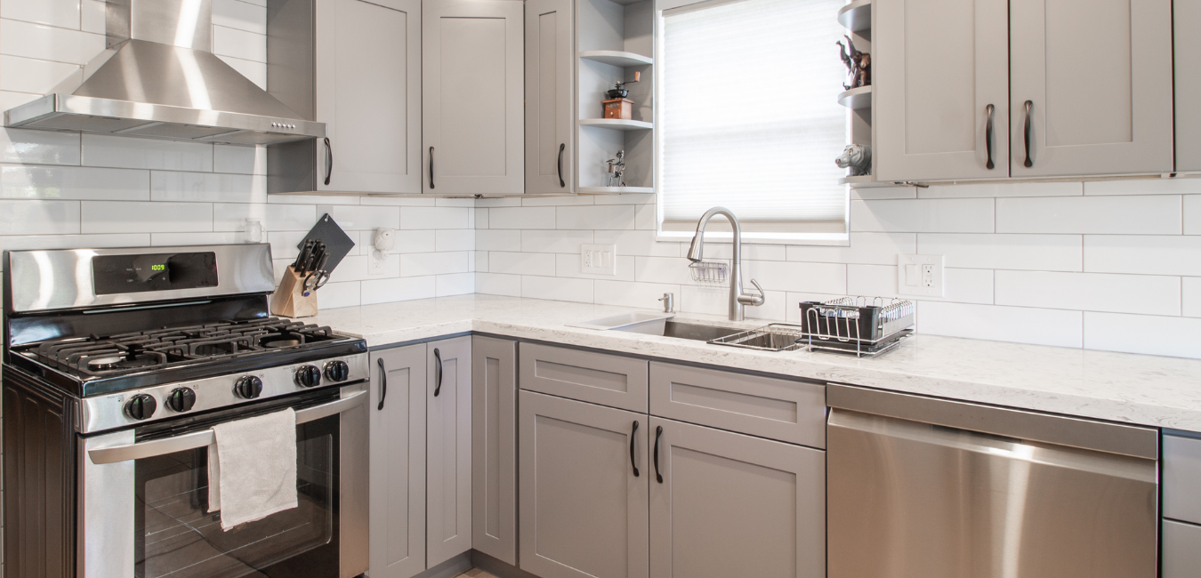 minor updated kitchen remodel with gray shaker style cabinets, new white subway tile backsplash and white veining quartz countertops