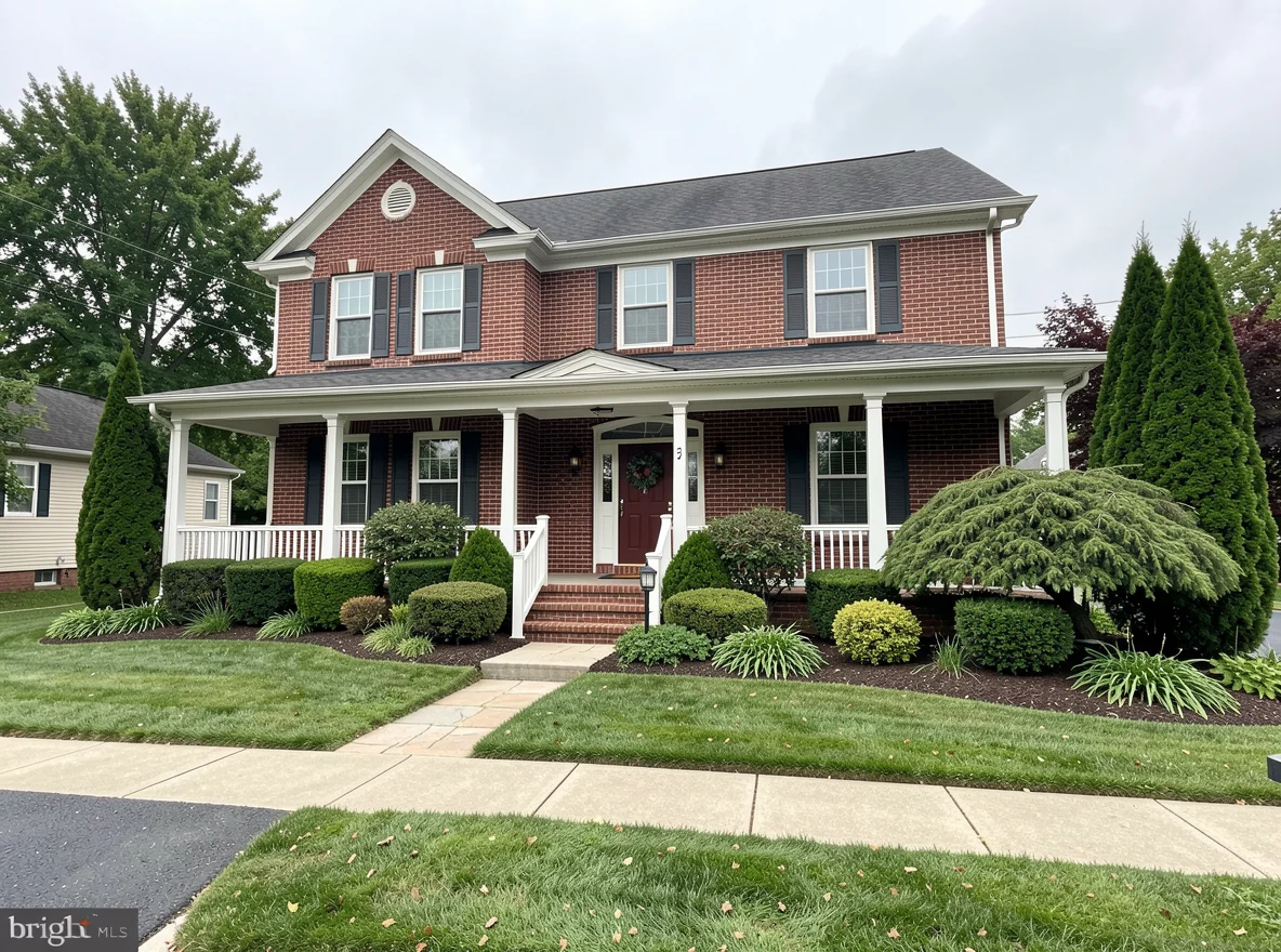 Brick home with front porch and mature landscaping