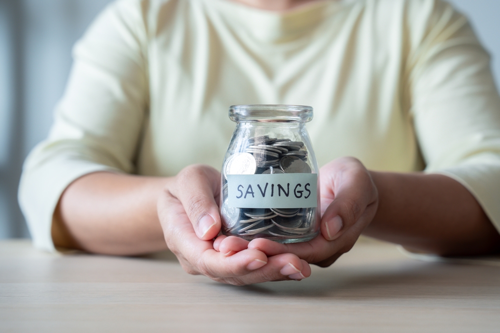 holding savings saved in a jar glass