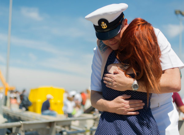 A Navy Officer Hugging his wife on the dock