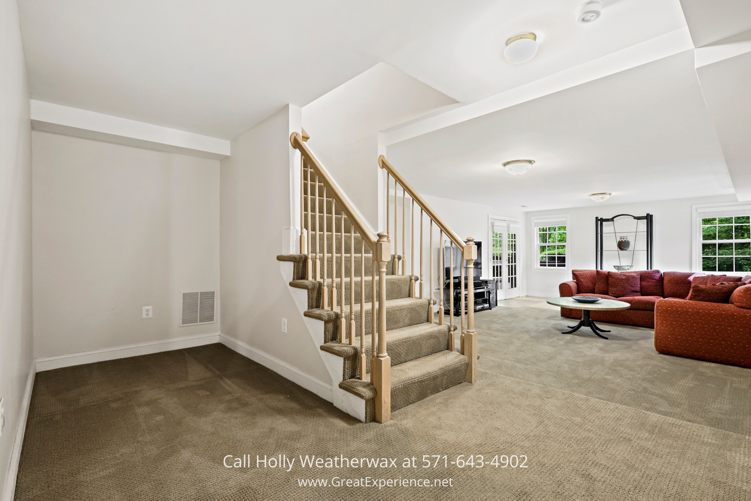 Spacious family room with abundant furniture and an elegant staircase