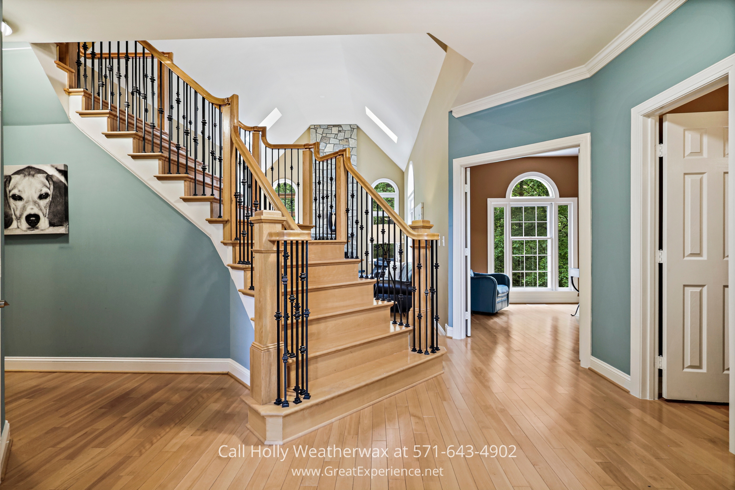 Elegant staircase in a house with striking blue walls and beautiful hardwood floors
