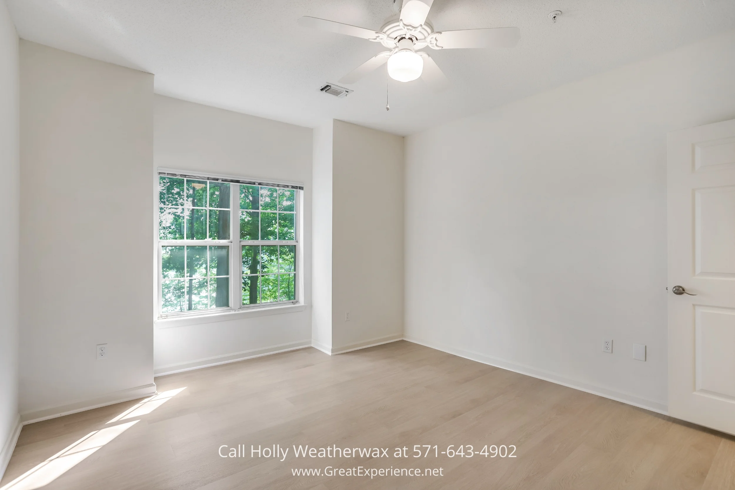 An empty room with white walls and wood floors