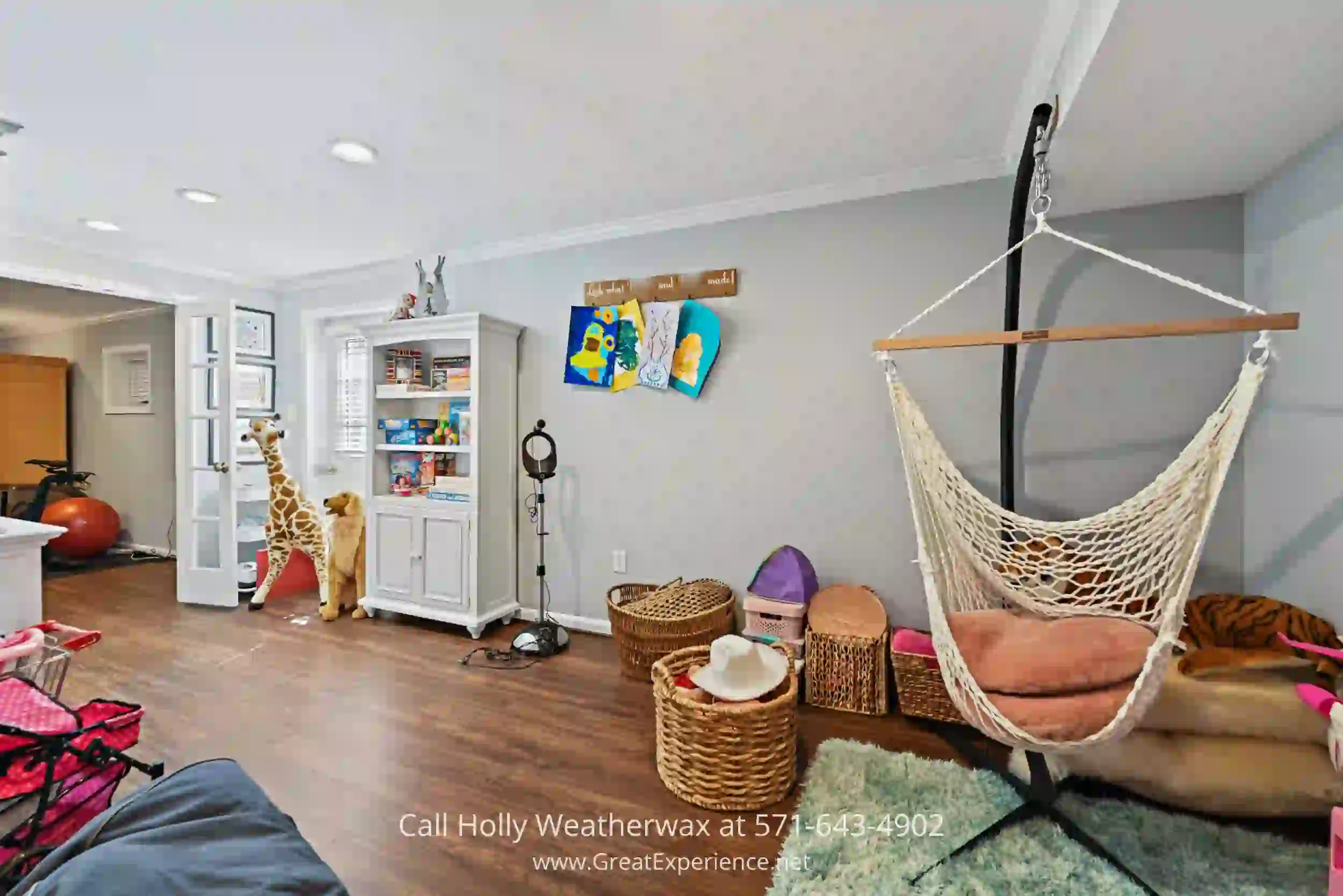 a family room with a hammock, chairs, and other items