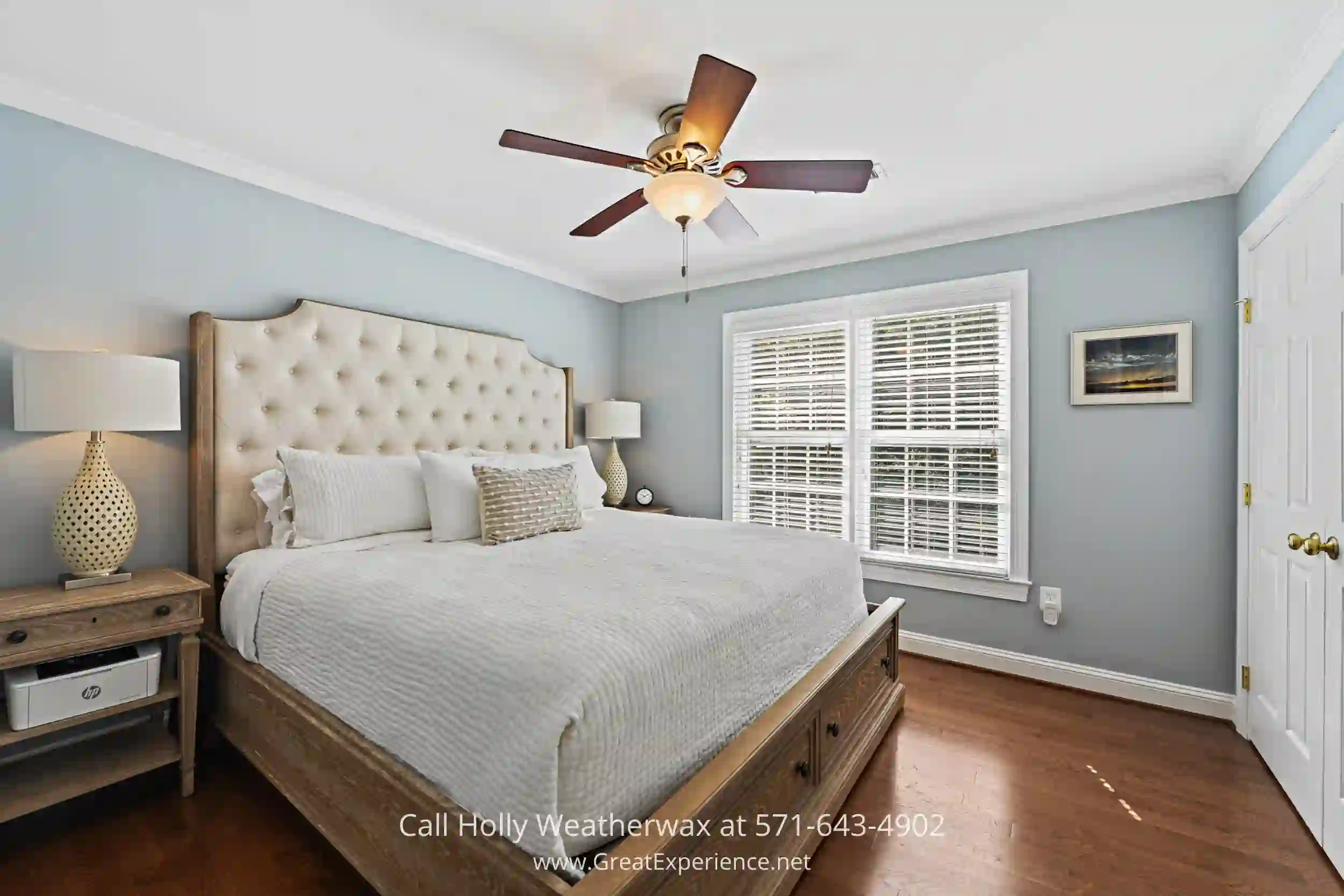 a bedroom with a neatly made bed and a ceiling fan