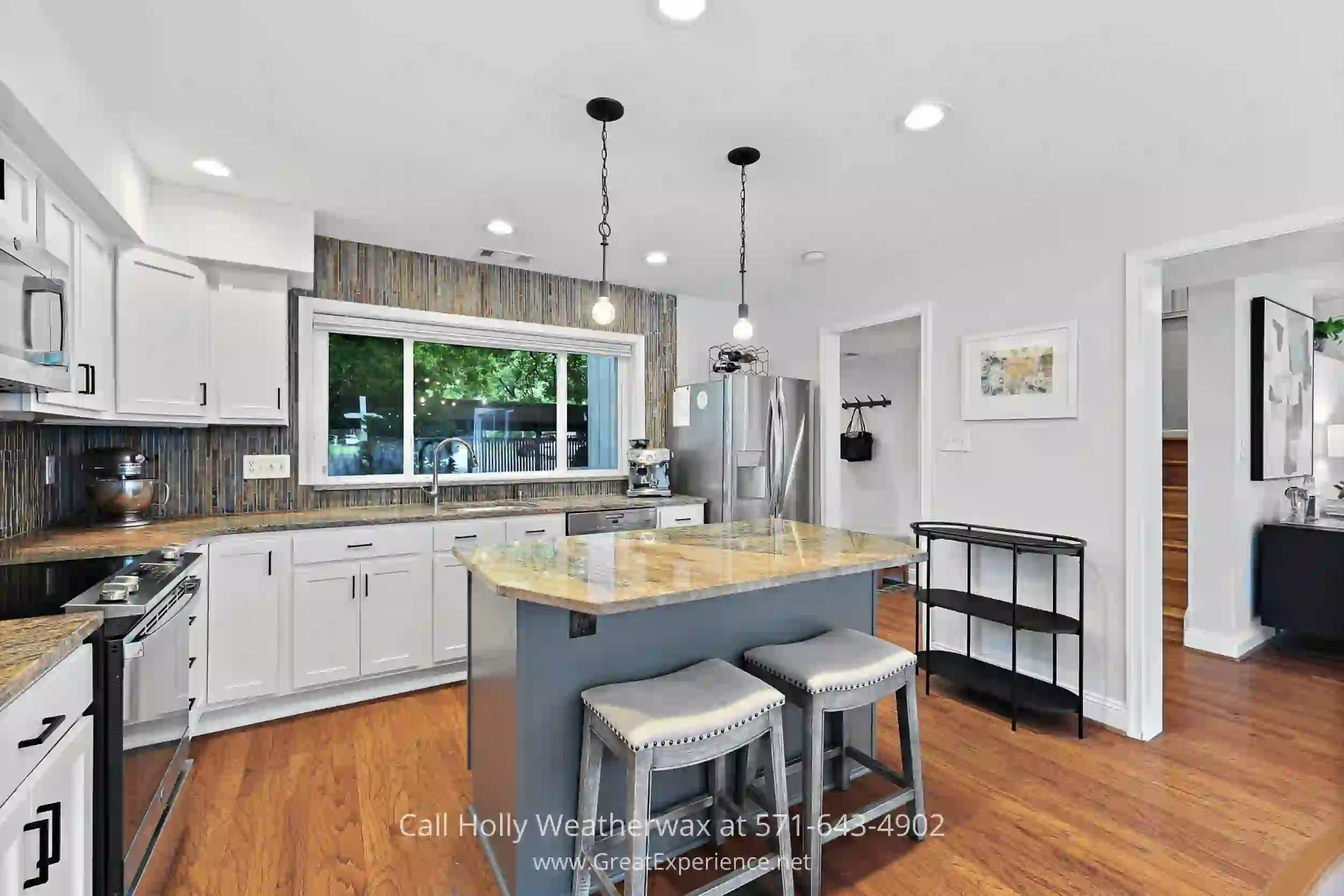 a kitchen with white cabinets and a center island with two stools