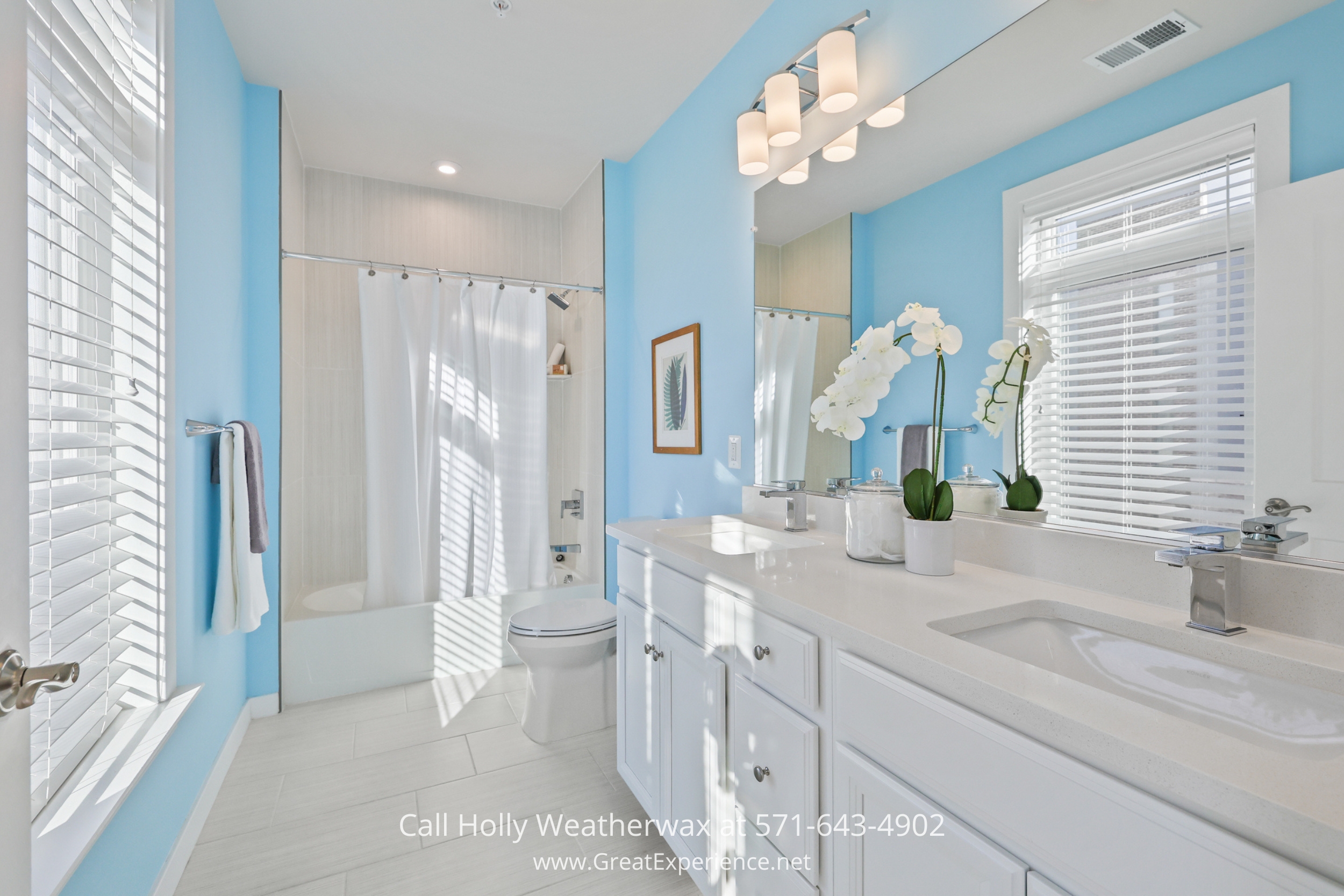 a bathroom with blue walls and white fixtures