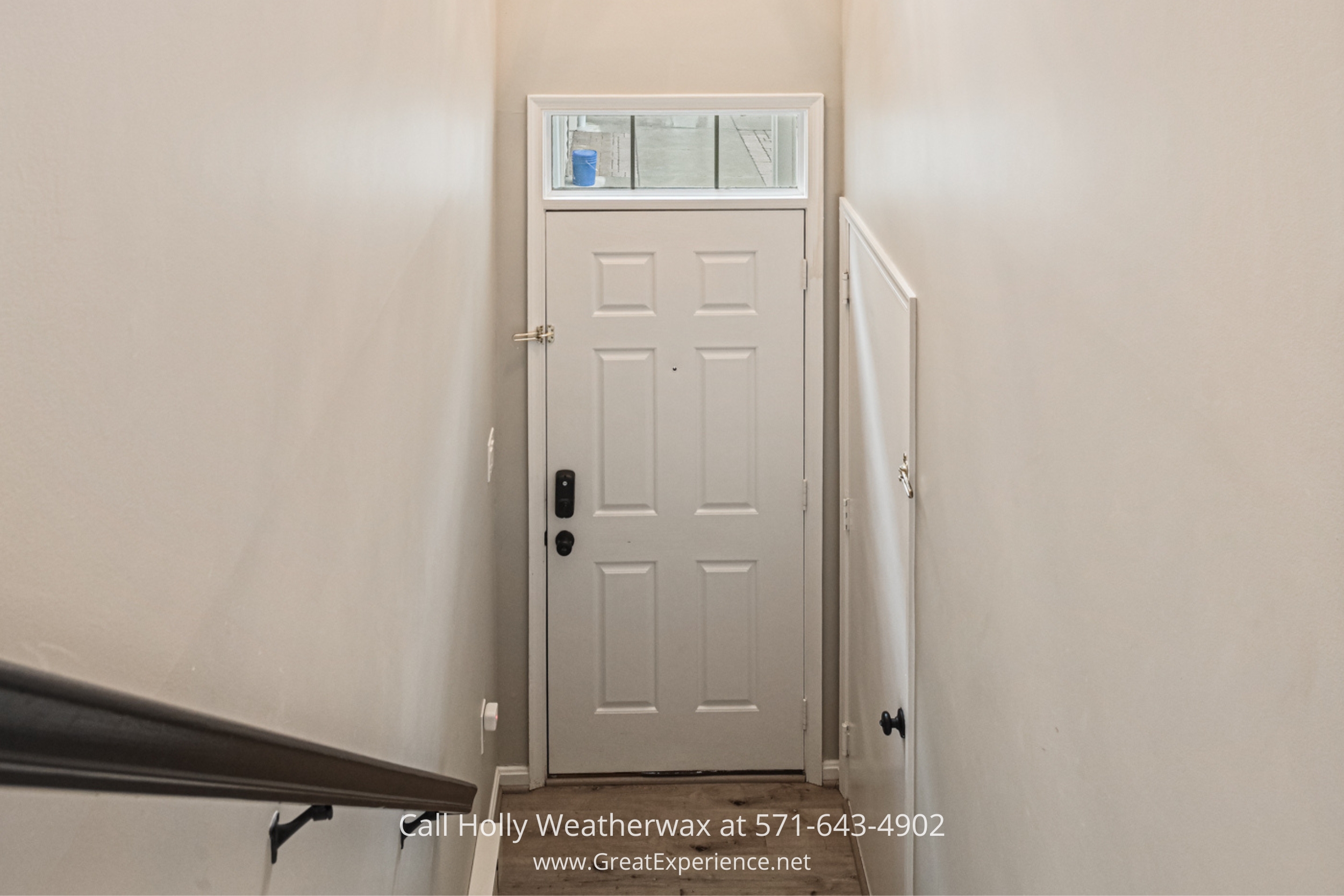 a hallway with a white door and a window