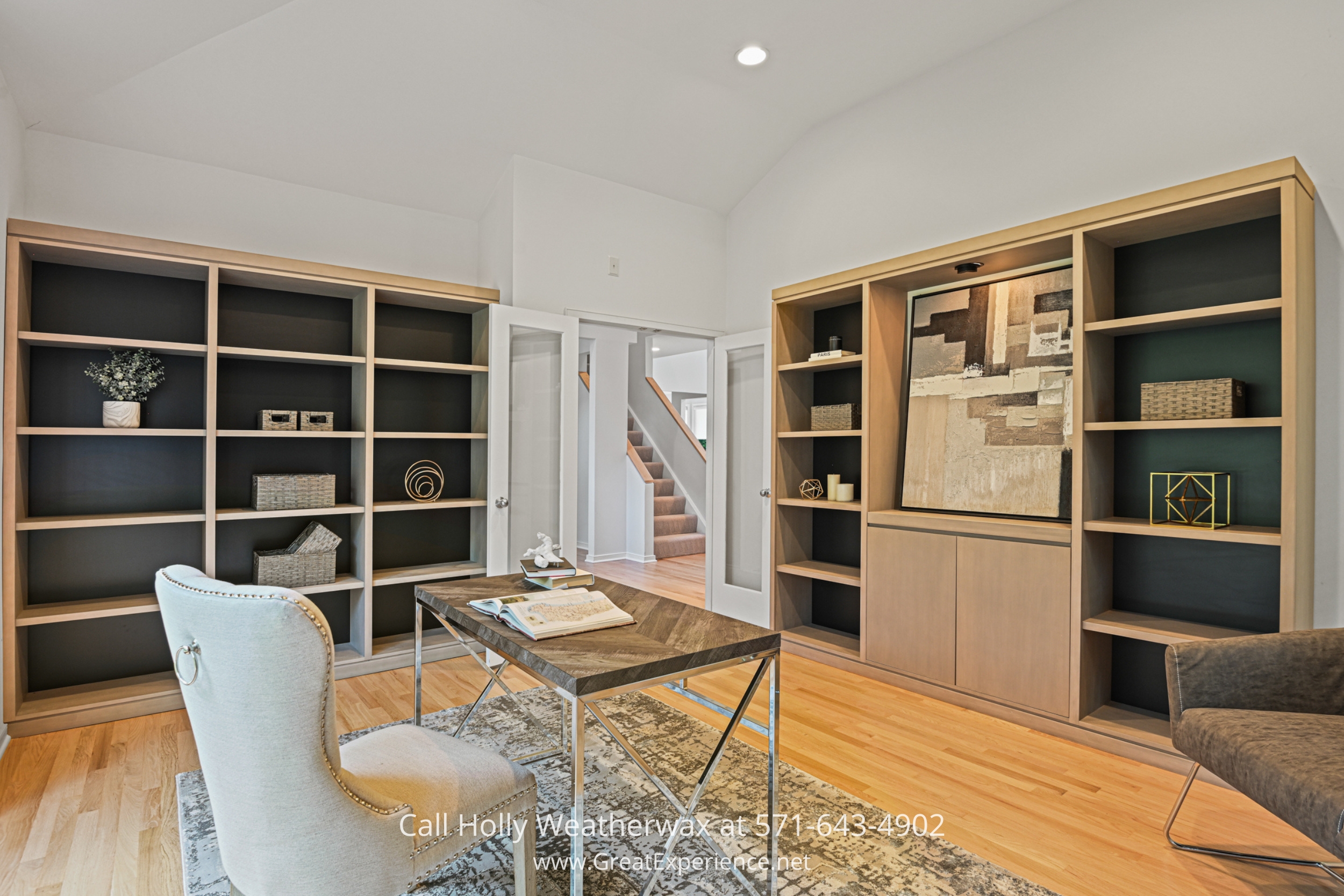 a living room with a bookcase and a desk