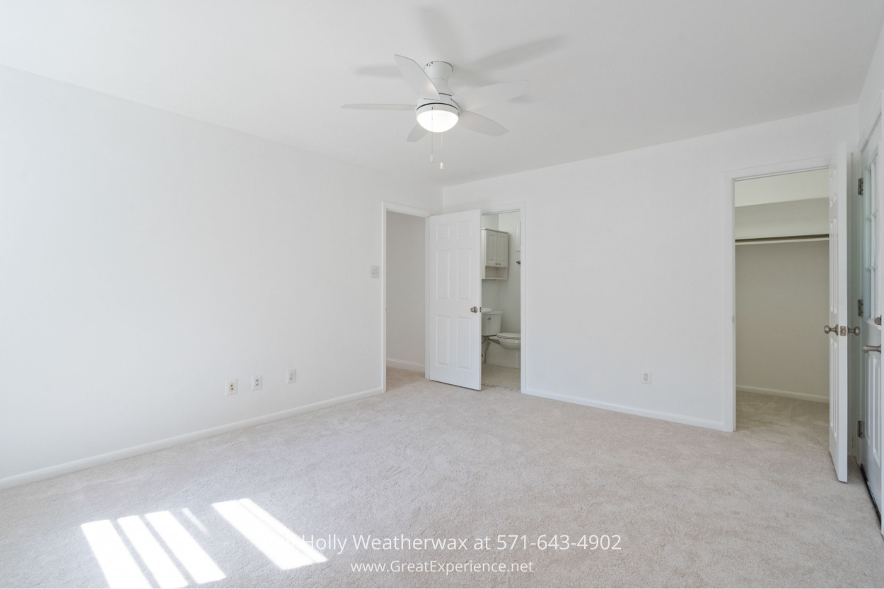 Spacious primary bedroom with ceiling fan, and direct access to an en-suite bathroom in this Chantilly VA home for sale.