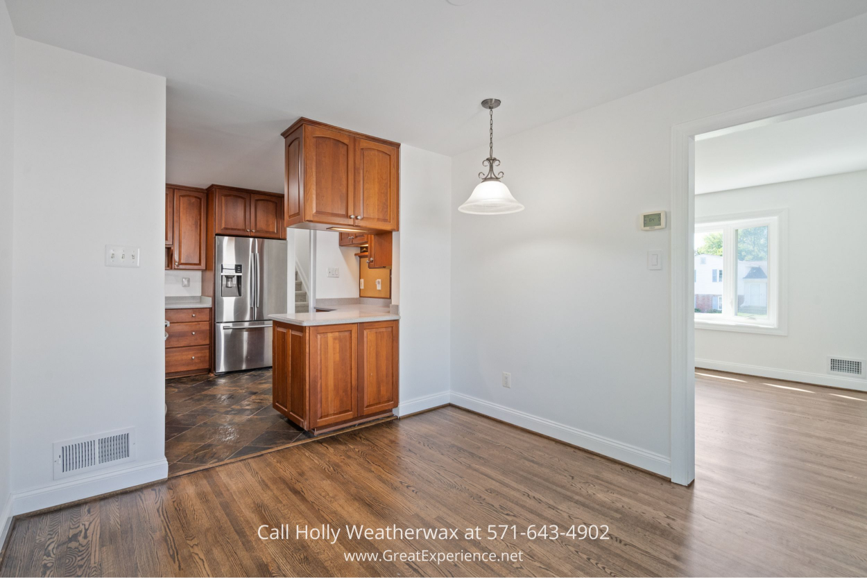 Cozy kitchen space with modern appliances, wood cabinetry, and open dining area in this Chantilly VA home for sale.