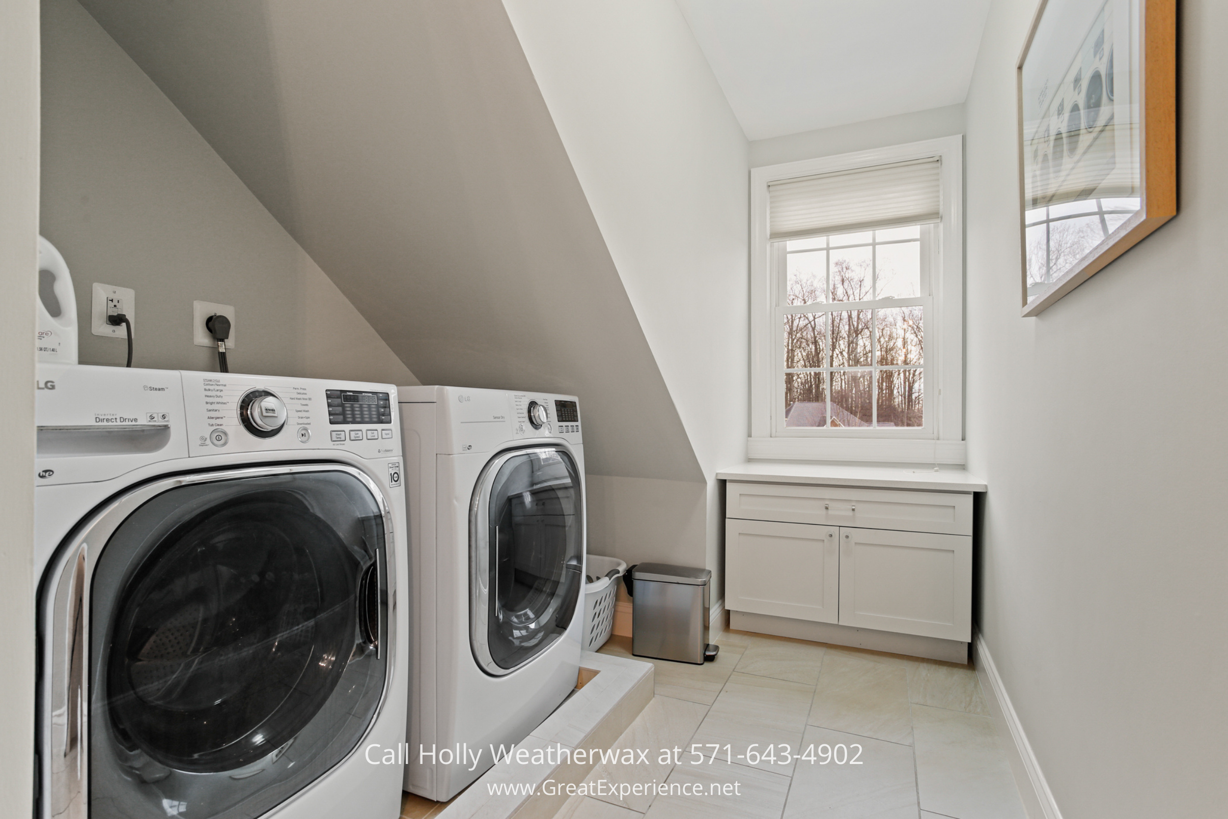Laundry room at 1110 Round Pebble Lane, Reston, VA, featuring front-loading washer and dryer, built-in cabinetry, and natural light.