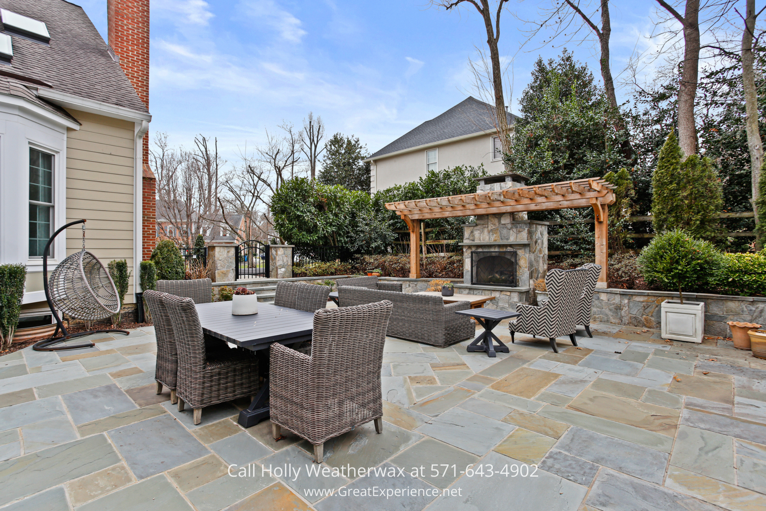 Stone patio at 1110 Round Pebble Lane, Reston, VA, featuring outdoor seating, pergola, and built-in fireplace.