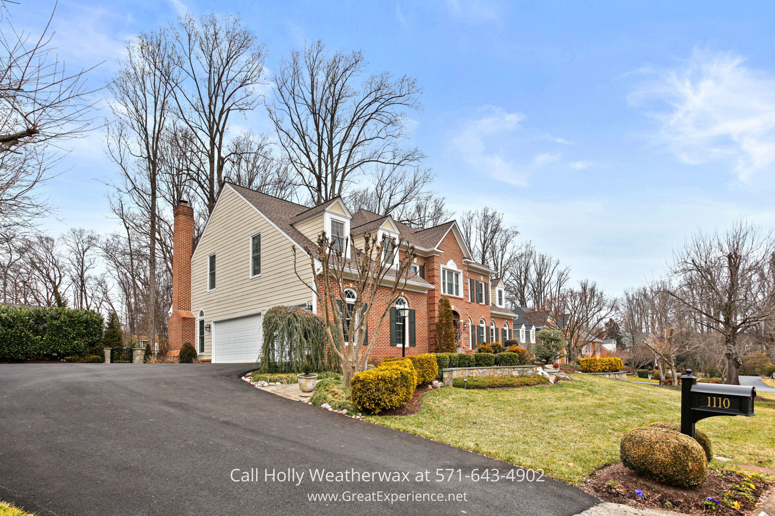 Front exterior of 1110 Round Pebble Lane in Reston, VA, a luxury brick home on a cul-de-sac with landscaped yard and curved driveway.