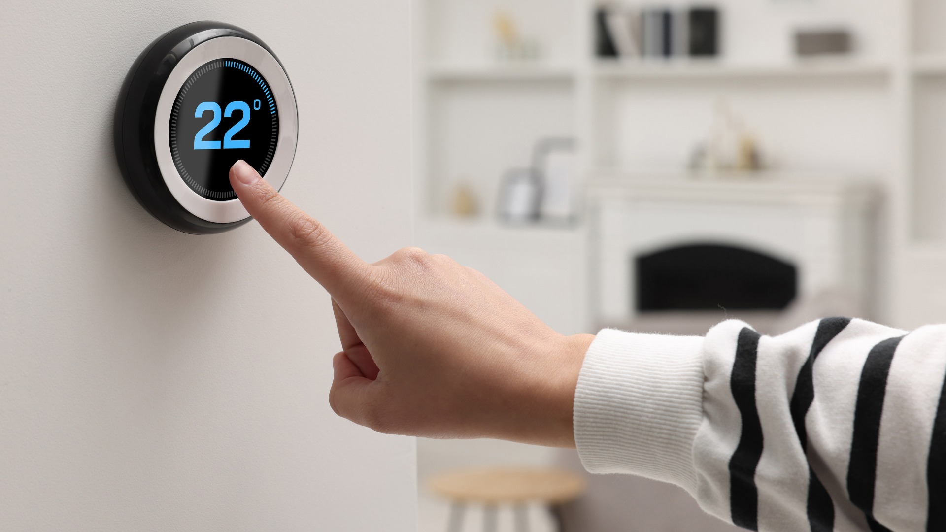 Smart DIY Home Repairs A person pressing a button on a smart thermostat while working on DIY home repairs.