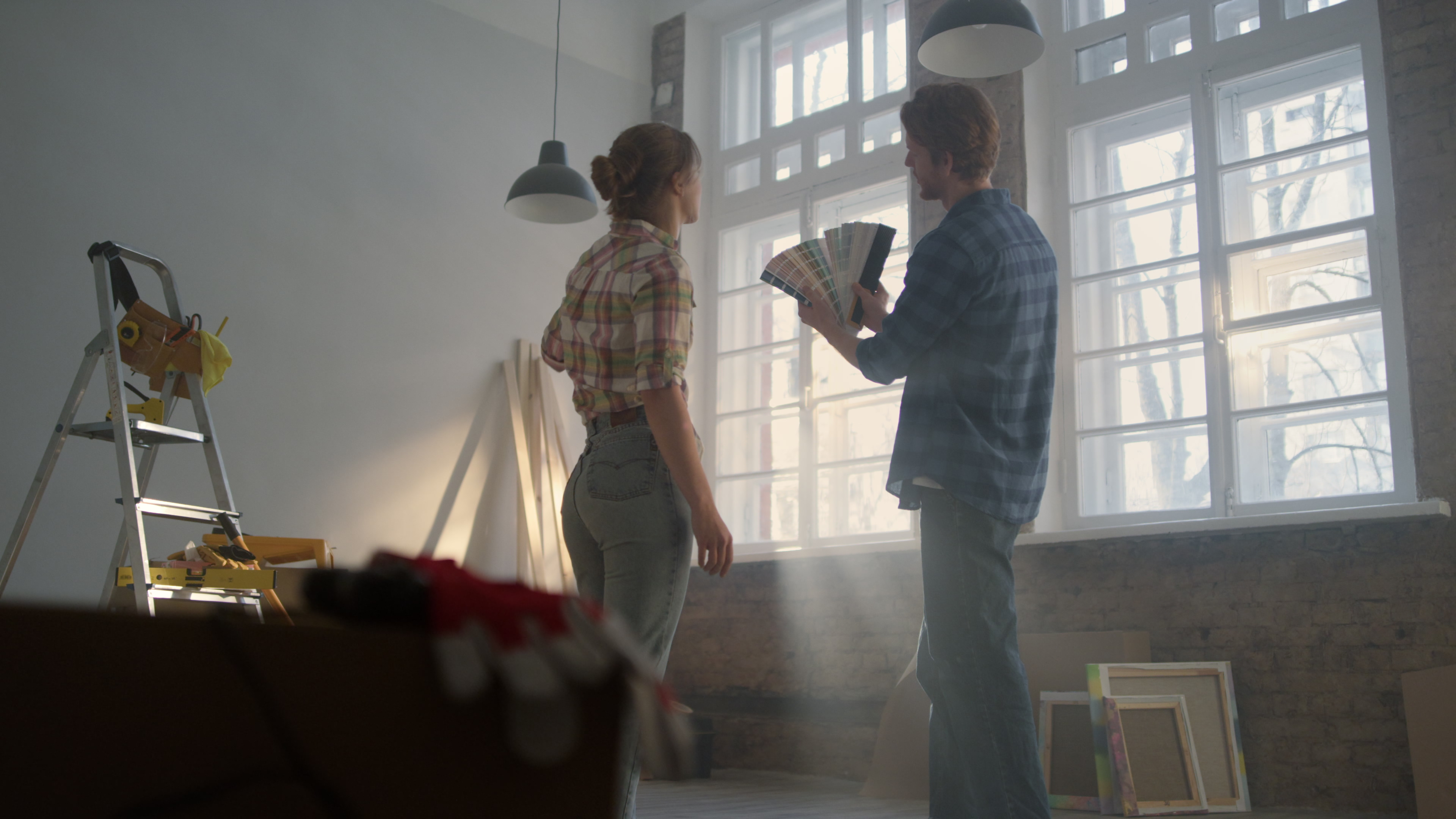 a man and a woman standing by the window