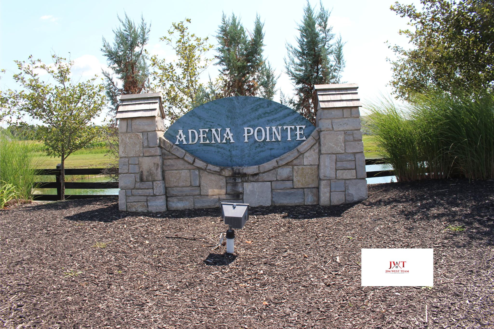 Stone entrance sign for Adena Pointe neighborhood in Marysville, Ohio, surrounded by landscaping and trees