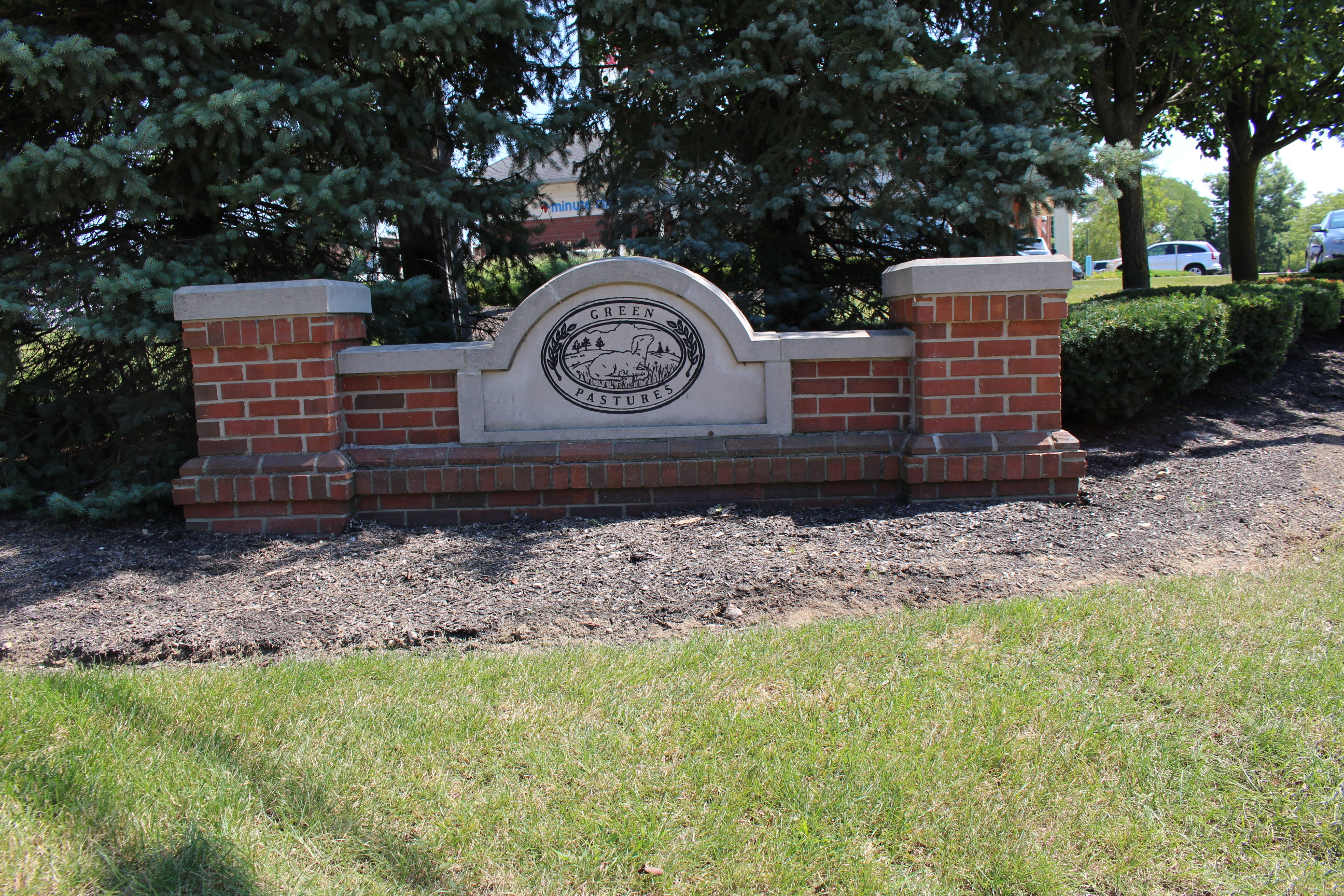 Green Pastures neighborhood entrance sign in Marysville, Ohio, featuring a brick base with decorative stone inlay surrounded by landscaping