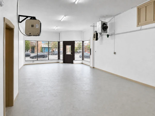 Empty, freshly painted open storefront space with a wall of street-facing windows at 6600 N Clark St