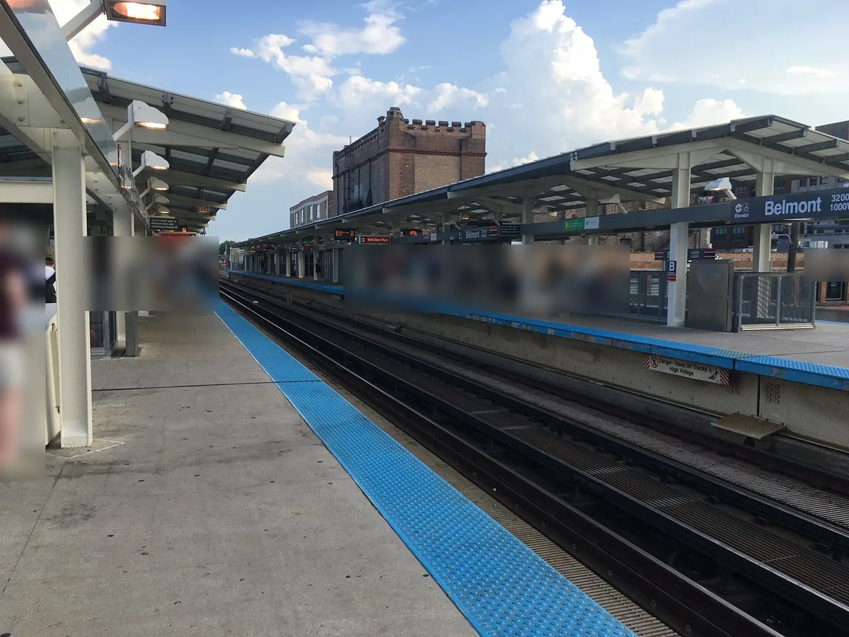 Belmont CTA station platform with blue tactile edge strip and a Belmont station sign in Chicago
