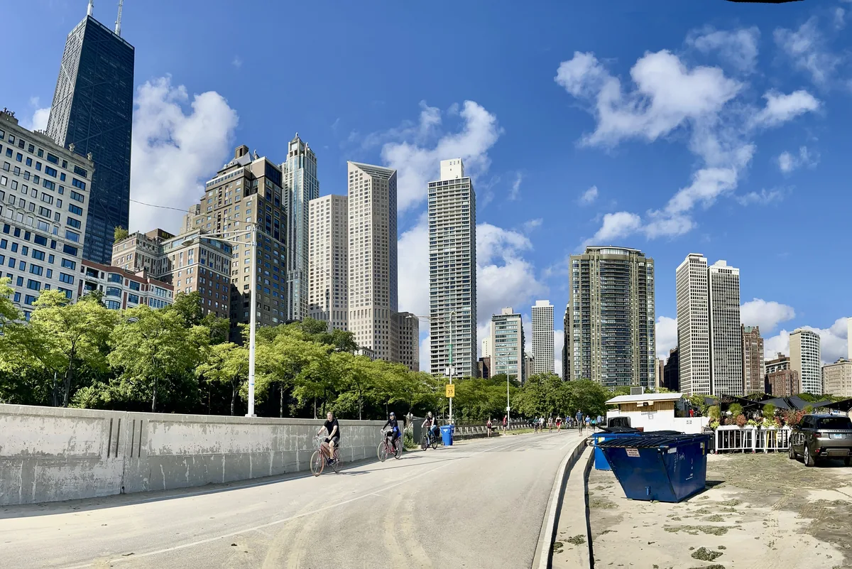 Cyclists on the Lakefront Trail near Oak Street with Gold Coast and Streeterville high-rises behind in Chicago