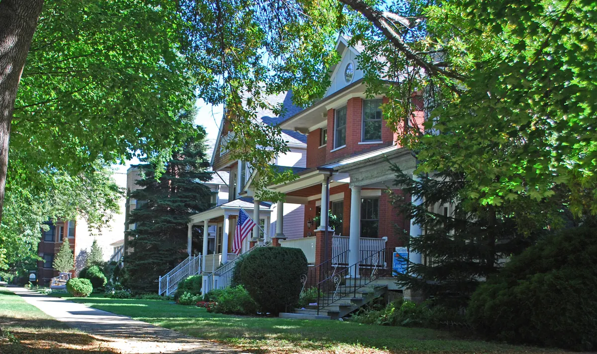 Tree-lined block of Hermitage Avenue near Irving Park Road in the East Ravenswood Historic District, Chicago, with front porches and lawns
