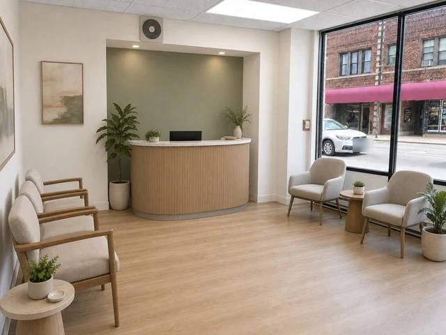 Front room at 6602 N Clark St shown virtually staged as a reception area with a desk, chairs and wood-look floors