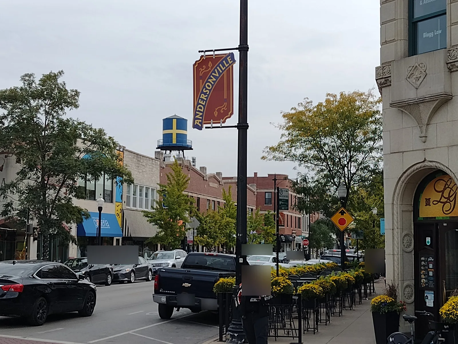 Andersonville restaurants with sidewalk seating on N Clark St in Chicago, a Swedish-flag water tower in the distance