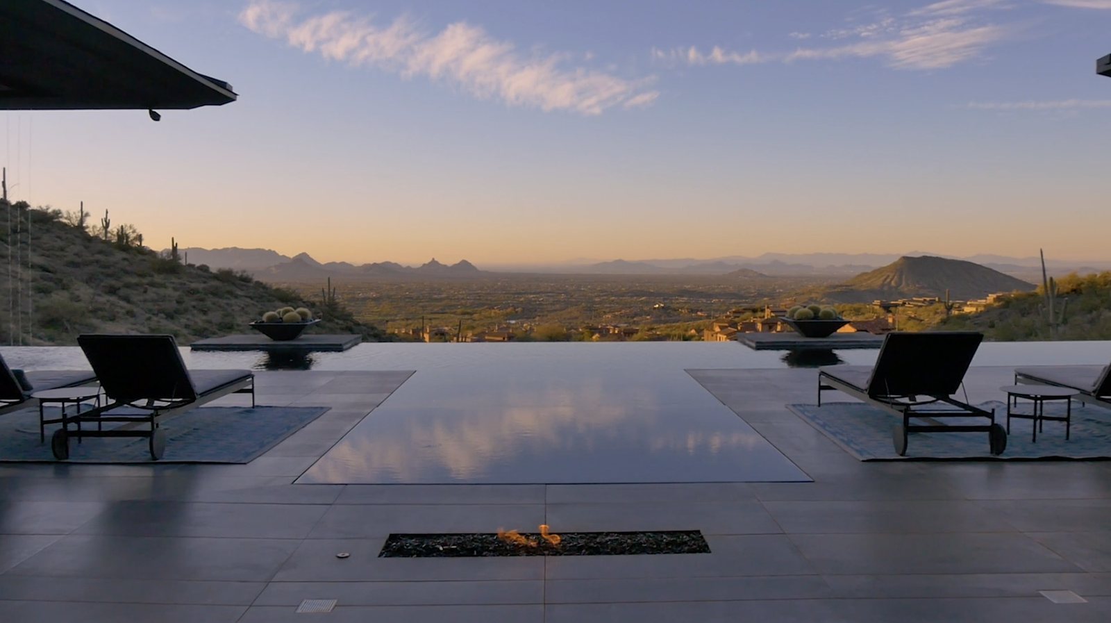Infinity pool and terrace at sunset looking out over the Valley from a Desert Mountain home