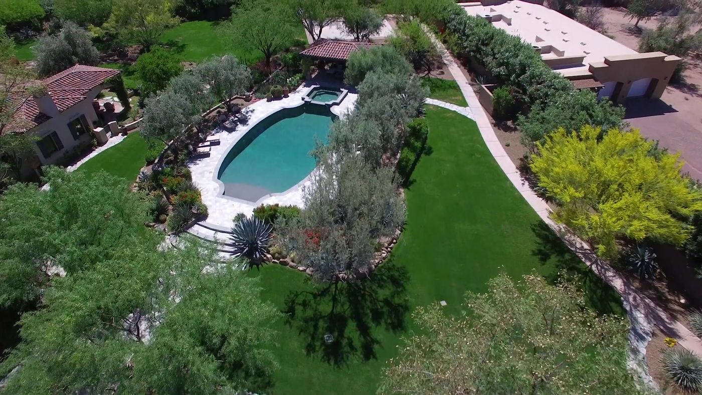 Aerial view of a Paradise Valley estate with a pool and lush gardens