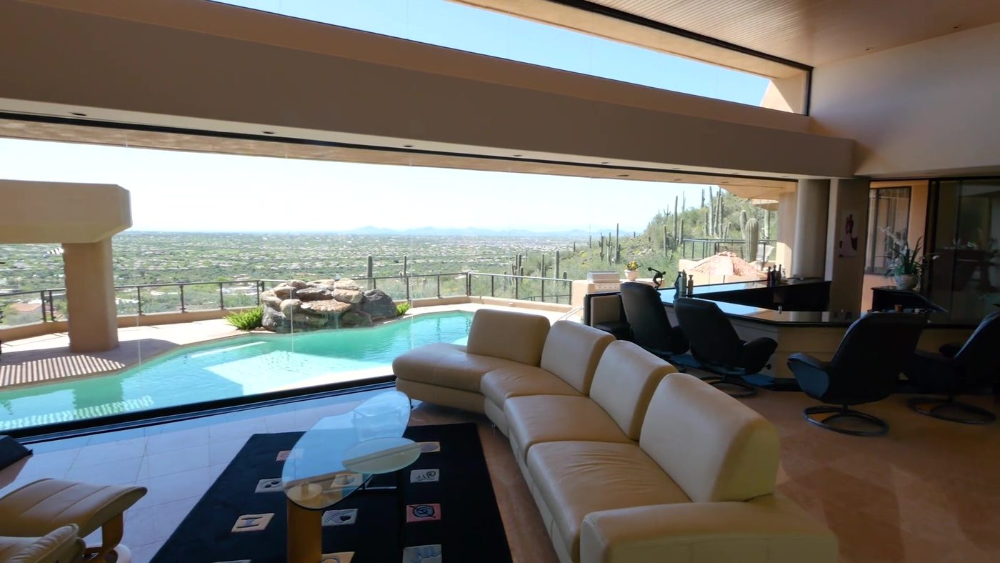 Living room of a Carefree hillside home opening onto a pool with views across the desert