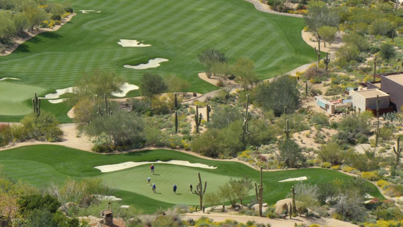 Aerial view of a desert golf course green among cactus and boulders near Carefree