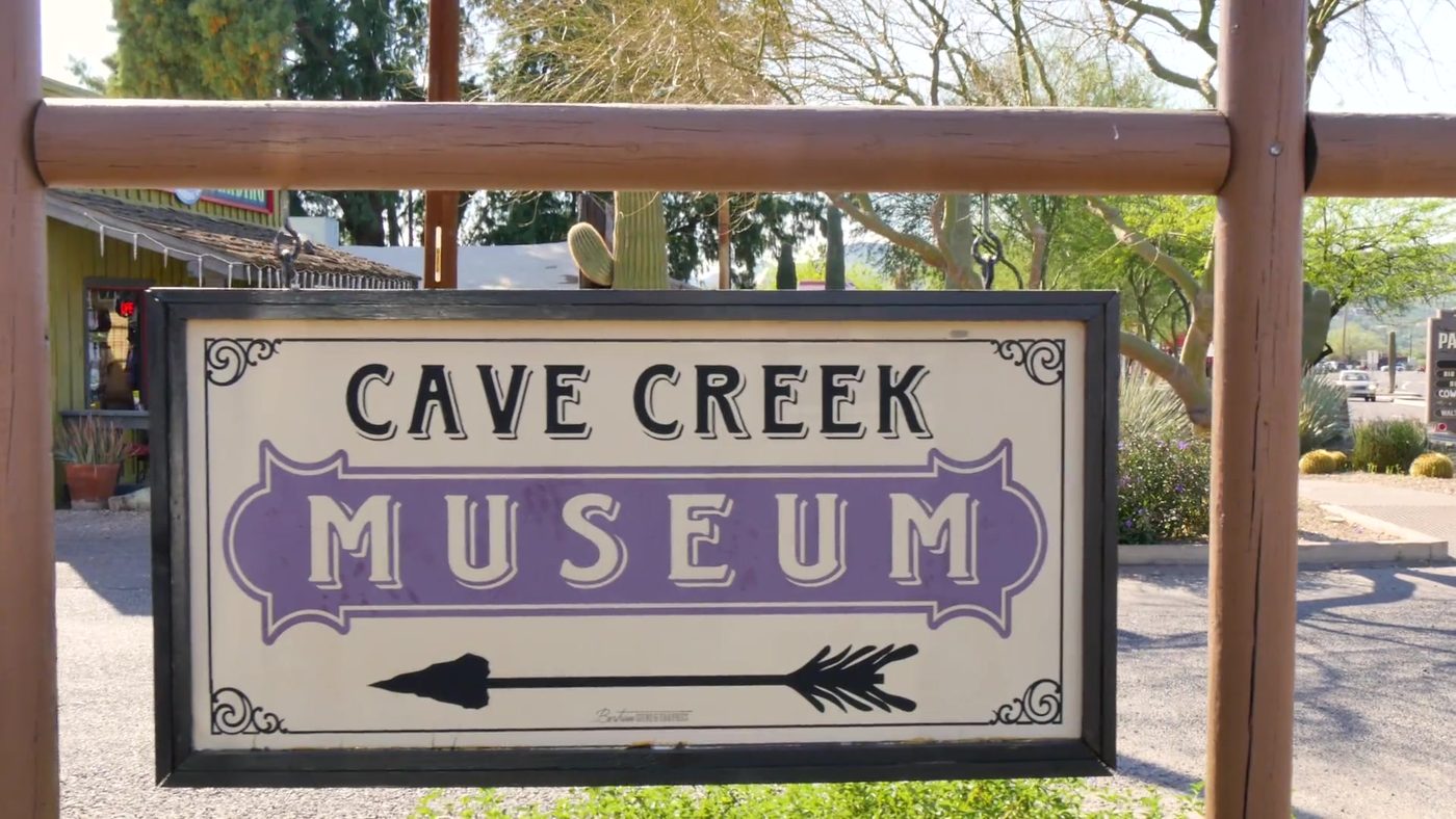 Cave Creek Museum sign with an arrow pointing the way