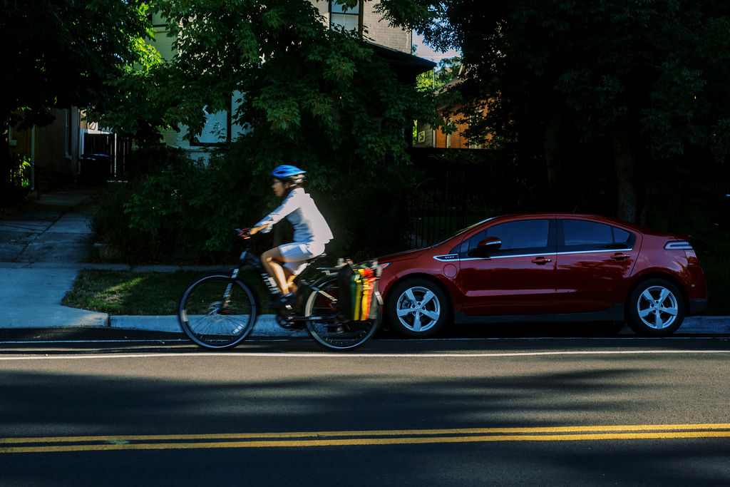 a person on a bicycle rides down the street