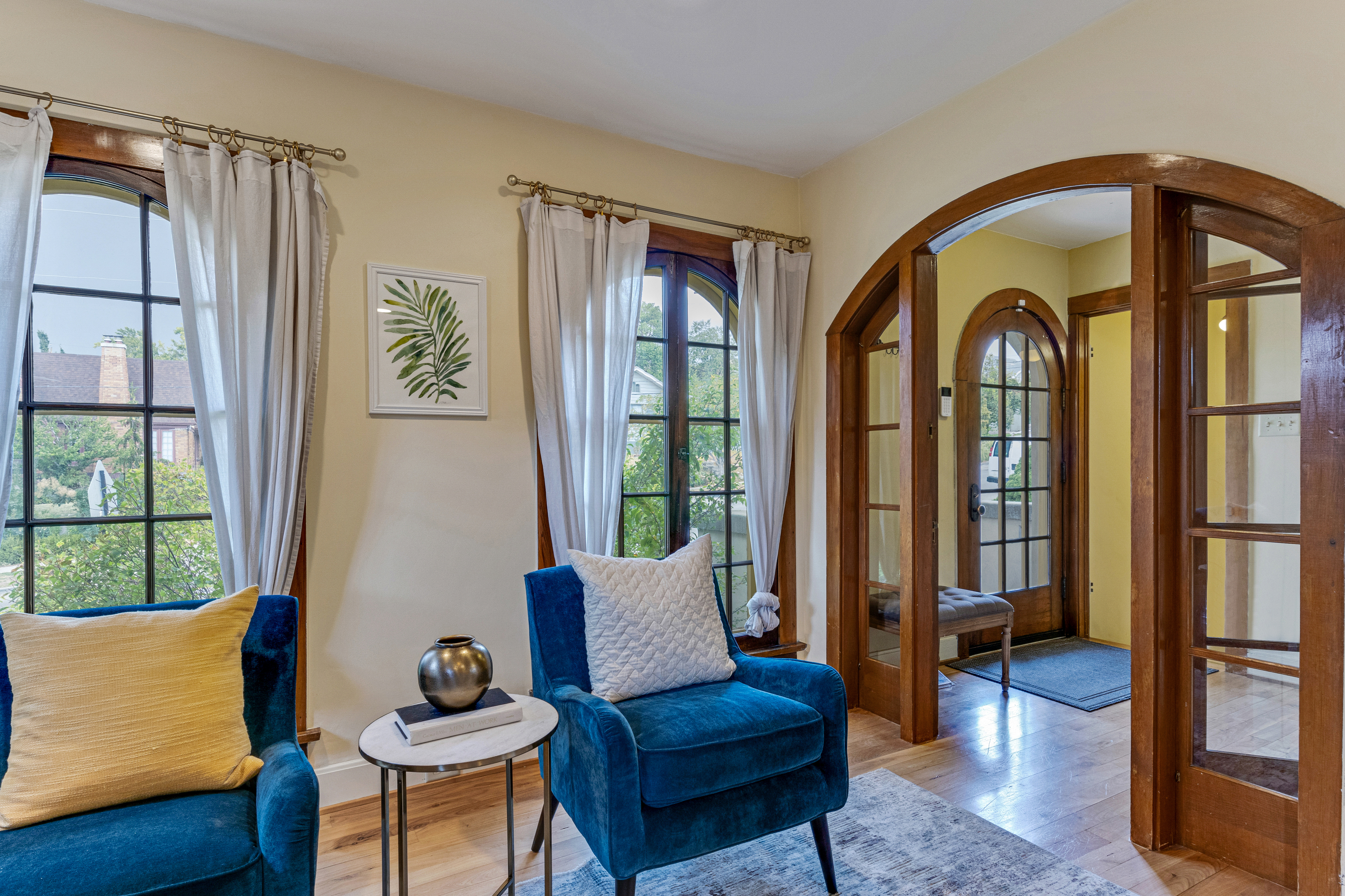 a beautiful living room with interior windows and blue velvet furniture