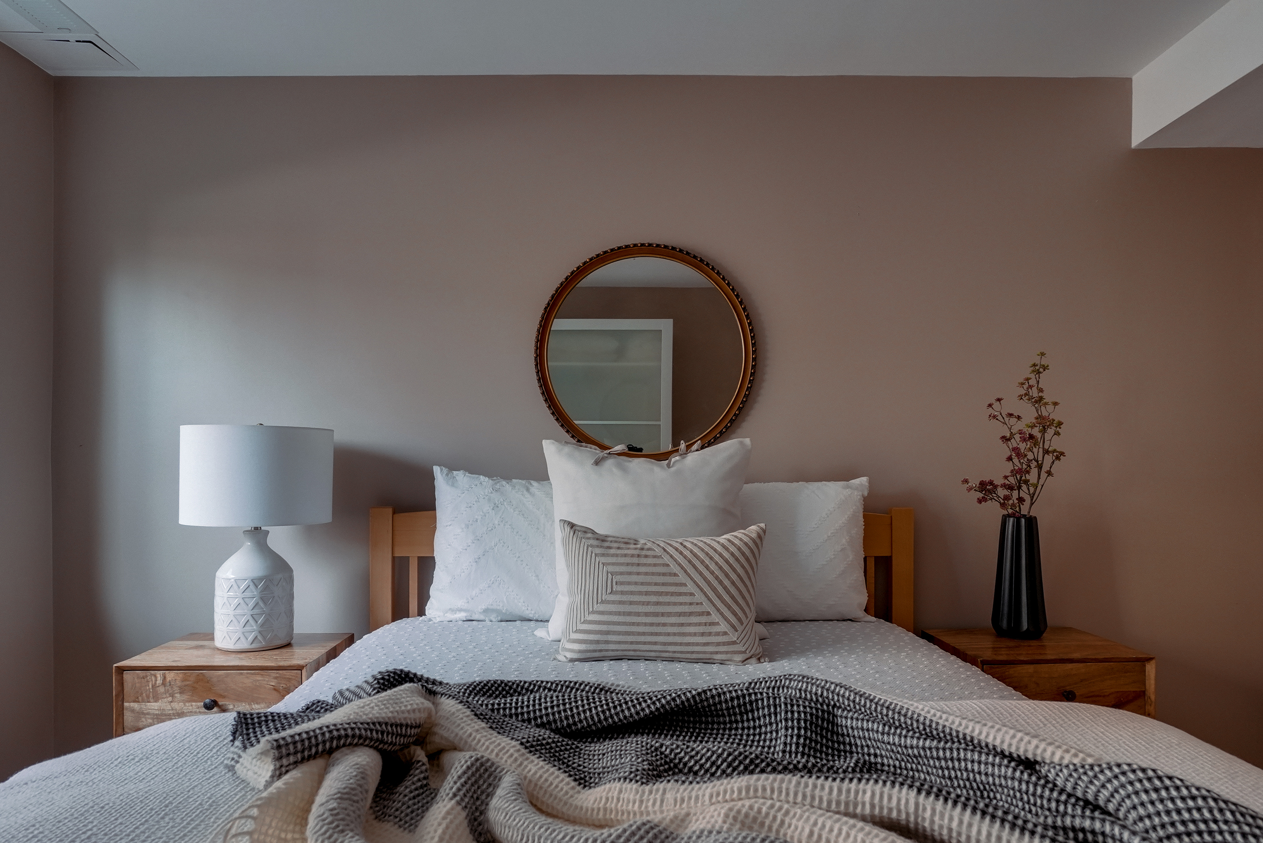 a modern bedroom with pillows and white lamp