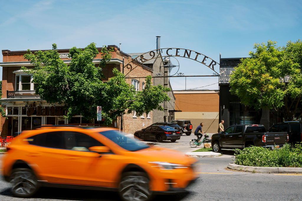 an orange car zooms past the 9th and 9th sign in salt lake city