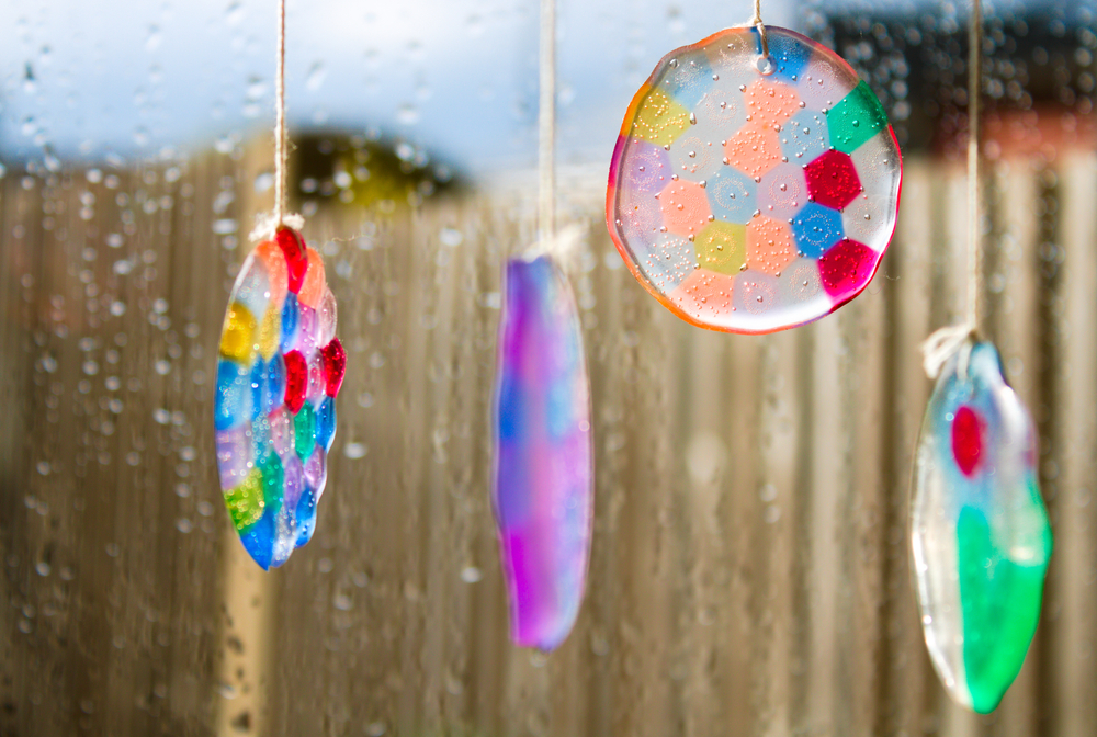 colorful homemade wind chimes placed on a window sill