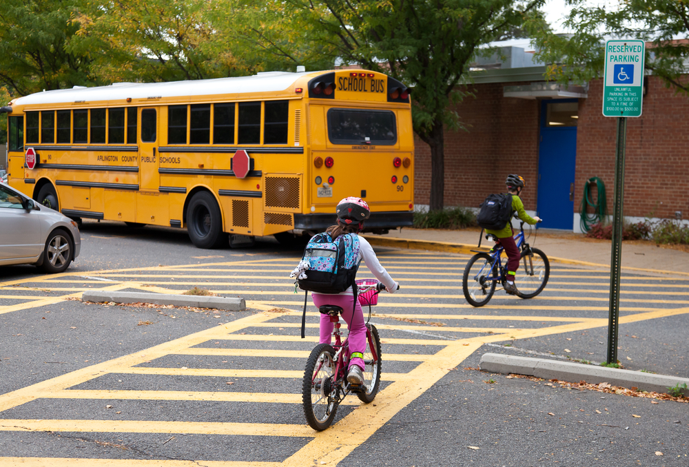 school bus and students riding their bikes going to school