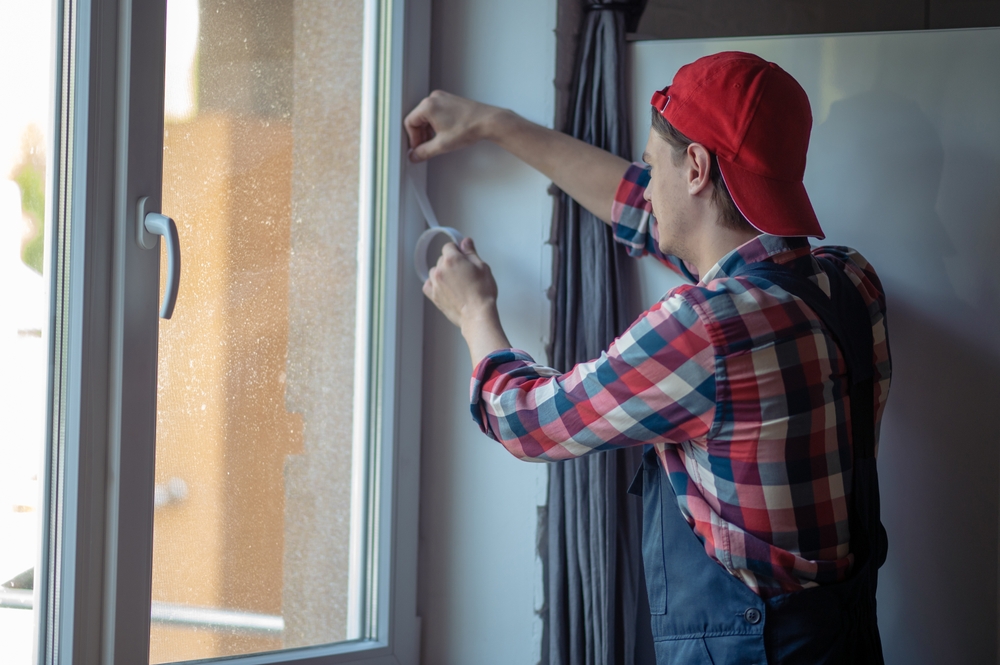 A man sealing the windows