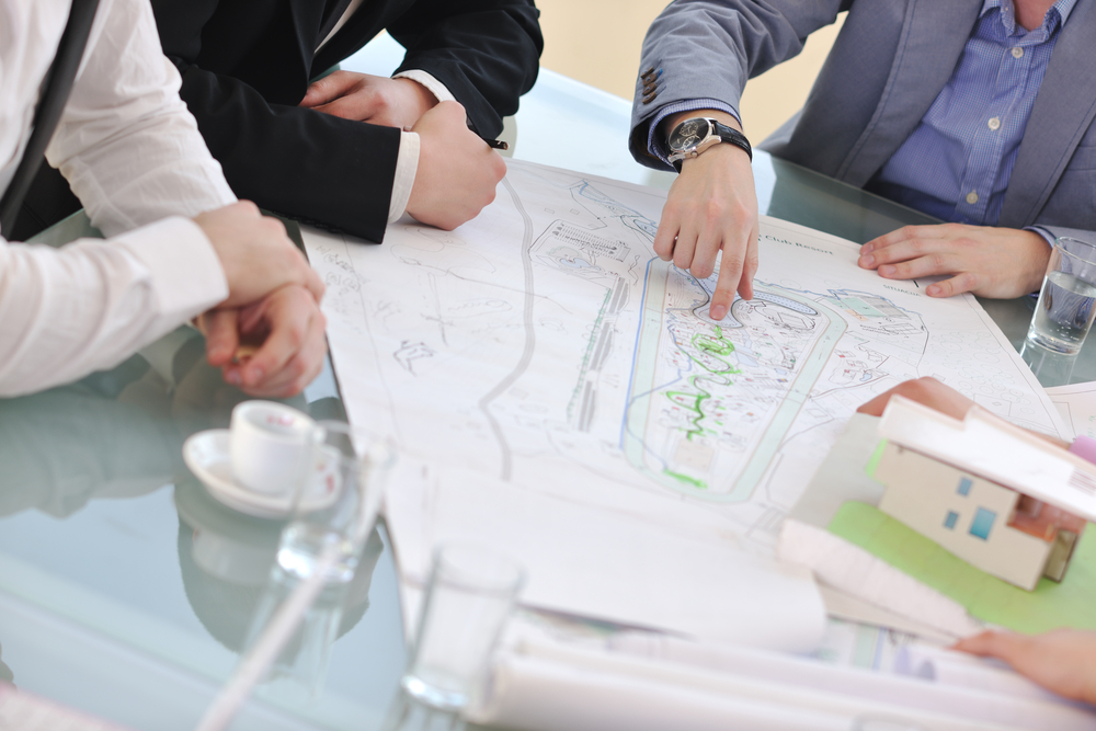 group of people looking at a blueprint